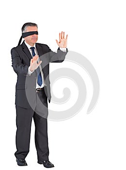 Mature businessman walking with blindfold photo