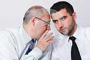 Mature businessman whisper something to colleague photo