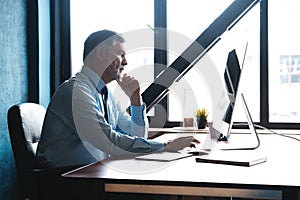 Mature Businessman Working On Computer In Office