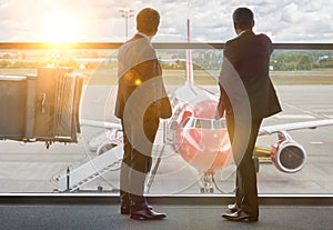 Mature businessmen standing while looking on the plane in airport