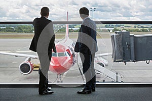 Mature businessmen standing while looking on the plane in airport