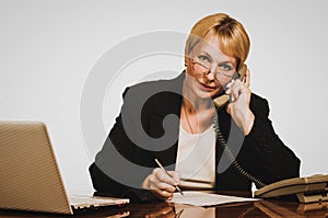 Mature businesswoman calling on the phone at her workplace