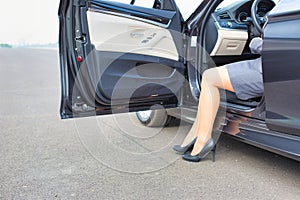 Mature businesswoman disembarking car