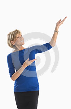 Mature Businesswoman Gesturing Towards Copy Space