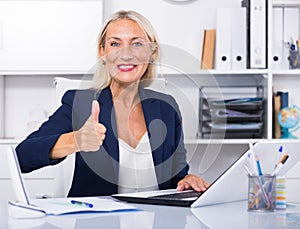 Mature businesswoman showing thumbs up