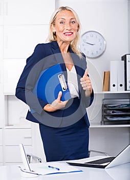 Mature businesswoman showing thumbs up