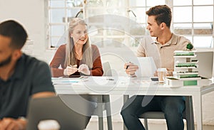 Mature businesswoman talking to a coworker. Two colleagues planning together. Businesspeople collaborate in an office