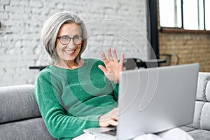 Mature businesswoman waving at the laptop