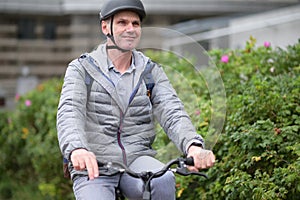 Mature Caucasian man in a bicycle helmet on his bike