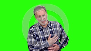 Mature caucasian man having a heart attack and touching his chest.