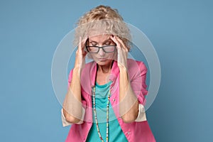 Mature caucasian woman in colored clothes touching her thead feeling stress photo