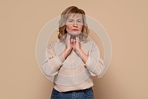 Mature caucasian woman with sore throat doing palpation. photo