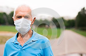 Mature cheerful pensioner man in medical mask protecting from the virus runs on stadium