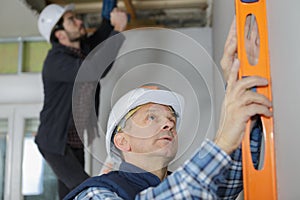 Mature construction worker using level