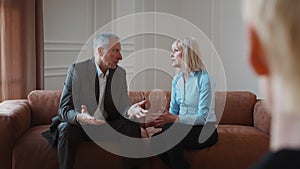 Mature Couple Arguing During Psychotherapy Session At Psychologist's Office