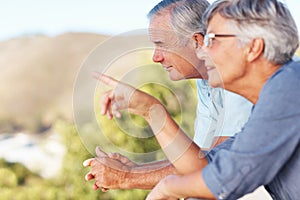 Mature couple in balcony. Focus on smiling mature man enjoying view from balcony with cheerful woman.