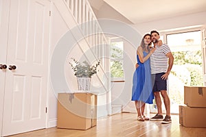 Mature Couple With Boxes Standing By Front Door Of New Home On Moving Day