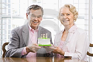 Mature couple with cake.