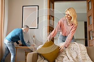 Mature Couple Cleaning Room Doing House Chores Together At Home