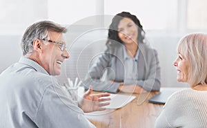 Mature couple consulting with financial adviser at home