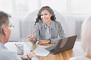 Mature couple consulting with financial adviser at office