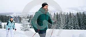 Mature couple cross country skiing outdoors in winter nature, Tatra mountains Slovakia.