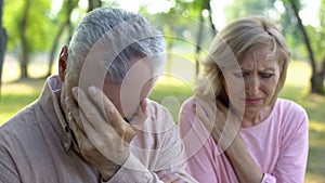 Mature couple crying sitting outdoors, incurable disease, retirement problem photo