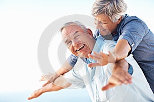 Mature couple enjoying golden years. Portrait of happy mature couple smiling while enjoying outdoors with arms