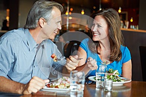 Mature Couple Enjoying Meal In Restaurant