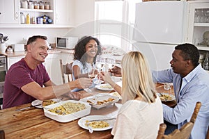 Mature Couple Entertaining Friends At Dinner Party