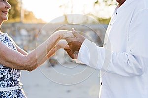 Mature couple holding hands in the sunset