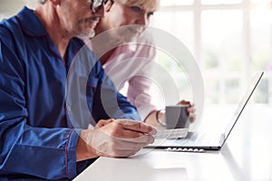 Mature Couple At Home Looking Up Information About Medication Online Using Laptop