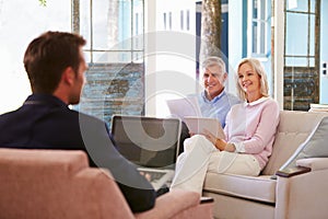 Mature Couple At Home Meeting With Financial Advisor