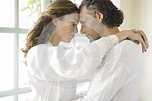 Mature Couple hugging by garden doors.