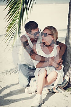 Mature couple hugging sitting at the beach