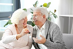 Mature couple with key from their new house in office of real estate agent
