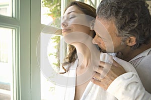 Mature Couple kissing by garden doors.