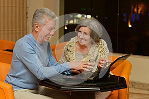 Mature couple with laptop in hotel