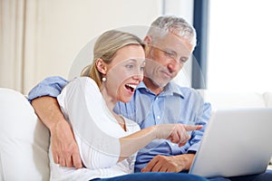 Mature couple, laptop and video call with conversation, smile and living room couch. Social media, technology and