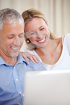 Mature couple, laptop and video call with laugh, conversation and living room couch. Social media, technology and