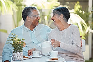 Mature couple laughing, drinking tea and bonding in backyard together, relax and cheerful outdoors. Senior man and woman