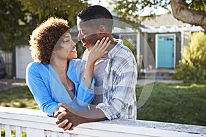 Mature Couple Leaning On Back Yard Fence