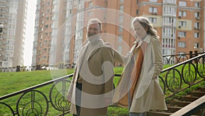 Mature couple in love happy Caucasian family senior middle-aged 60s old woman man walking outdoors urban walk partners