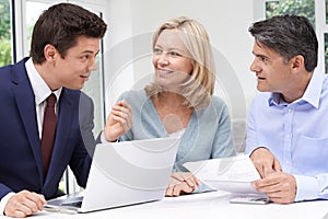 Mature Couple Meeting With Financial Advisor At Home