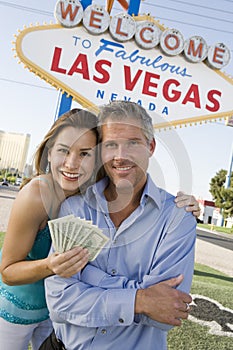 Mature Couple With Money And Welcome Sign In The Background