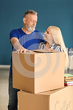 Mature couple with moving boxes at new home