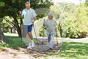 Mature couple Nordic walking at park