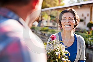 Mature Couple Outdoors Choosing Plants To Buy At Garden Center