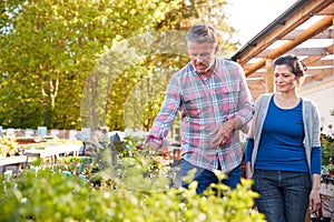 Mature Couple Outdoors Choosing Plants To Buy At Garden Center