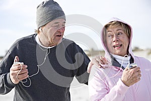 Mature couple outdoors listening to mp3 players photo